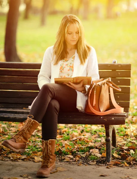 Mulher lendo livro no parque de outono — Fotografia de Stock