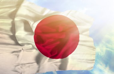 Mavi gökyüzü ile yapraklara karşı bayrak sallayarak Japonya