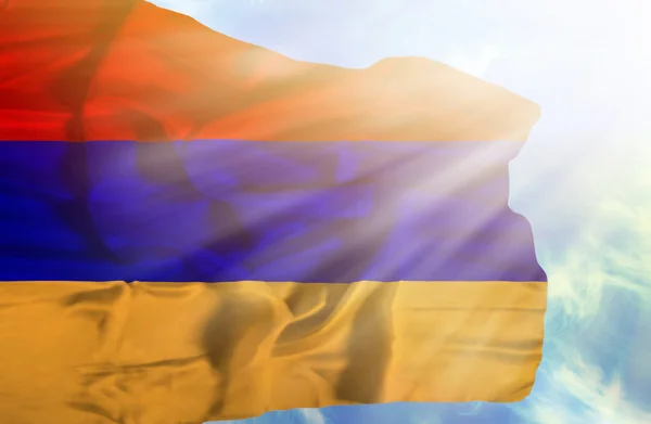 Армения машет флагом на фоне голубого неба с солнечными лучами — стоковое фото