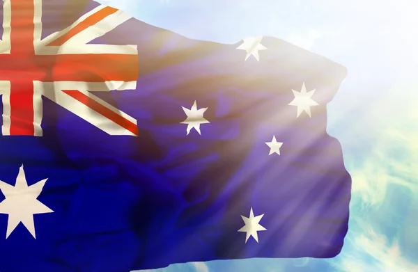 Australia waving flag against blue sky with sunrays — Stock Photo, Image