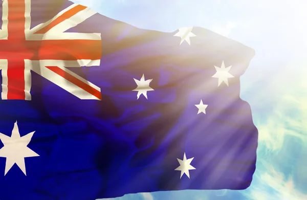 Australien viftande flagga mot blå himmel med solstrålar — Stockfoto