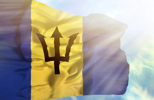 Barbados agitando bandeira contra o céu azul com raios de sol — Fotografia de Stock