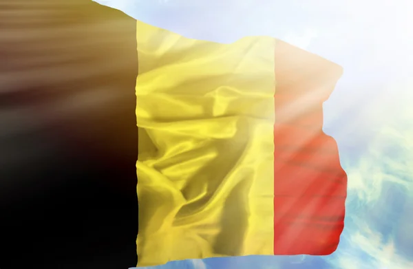 Il Belgio sventola bandiera contro il cielo blu con i raggi del sole — Foto Stock