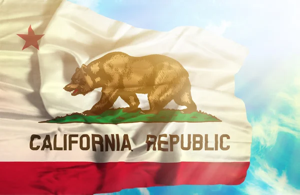 Kalifornien viftande flagga mot blå himmel med solstrålar — Stockfoto