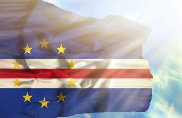 Кабо-Верде размахивает флагом против голубого неба с солнечными лучами — стоковое фото
