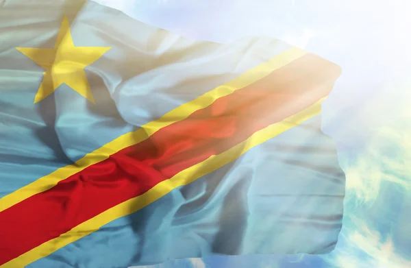 Kongo-Kinshasa viftande flagga mot blå himmel med sunr — Stockfoto