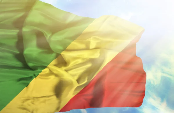 Congo Republik vinker flag mod blå himmel med solstråler - Stock-foto