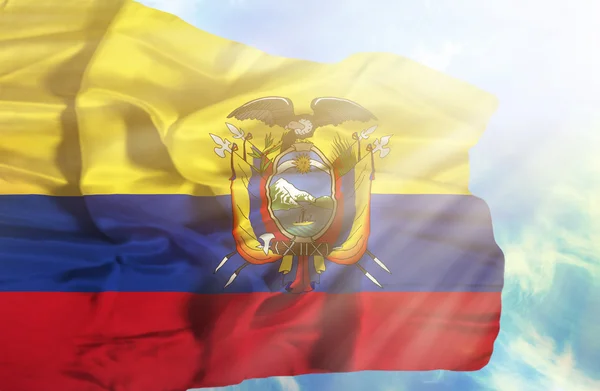 Ecuador waving flag against blue sky with sunrays — Stock Photo, Image