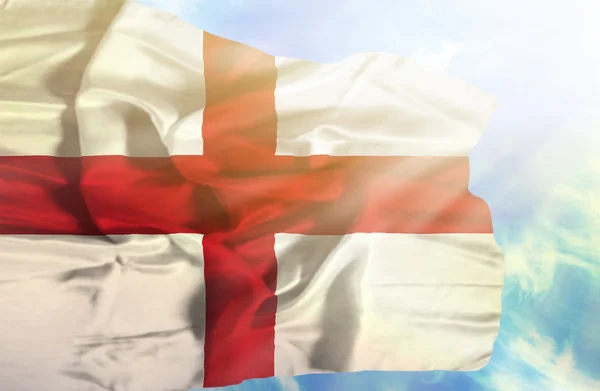 England schwenkt Flagge gegen blauen Himmel mit Sonnenstrahlen — Stockfoto