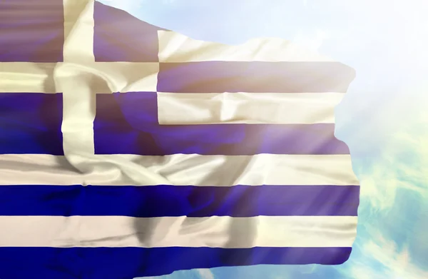 Greece waving flag against blue sky with sunrays — Stock Photo, Image