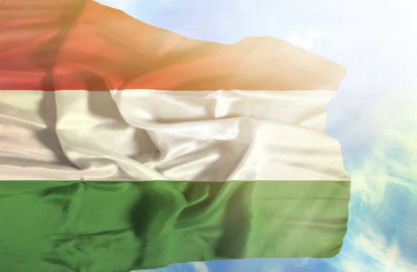 Ungern viftande flagga mot blå himmel med solstrålar — Stockfoto