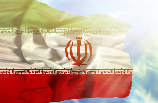 Iraner schwenken Flagge gegen blauen Himmel mit Sonnenstrahlen — Stockfoto