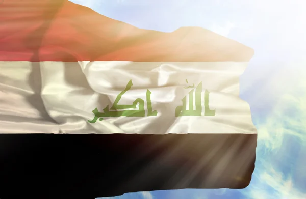 Iraq waving flag against blue sky with sunrays — Stock Photo, Image