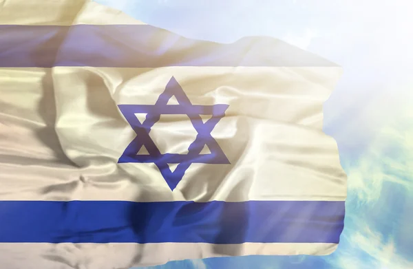 Israel schwenkt Flagge gegen blauen Himmel mit Sonnenstrahlen — Stockfoto