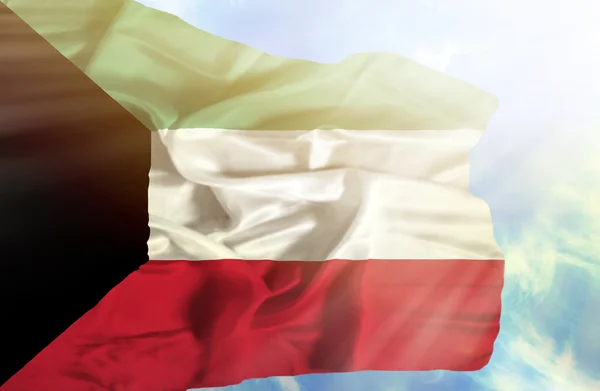 Koeweit zwaaien vlag tegen blauwe hemel met zonnestralen — Stockfoto
