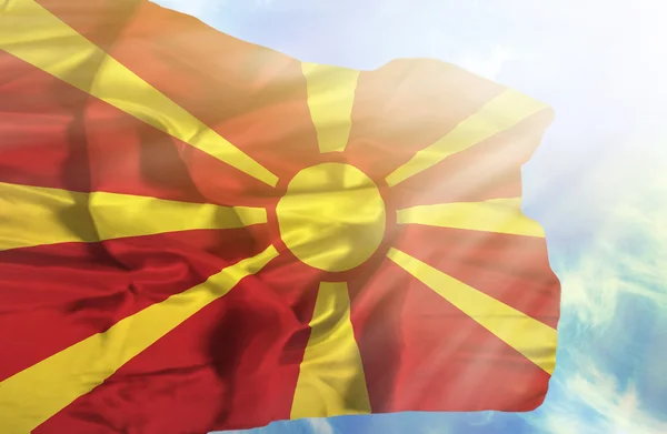 Macedonia ondeando bandera contra el cielo azul con rayos de sol — Foto de Stock