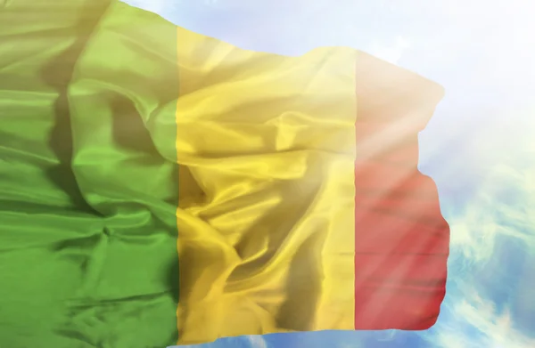 Mali zwaaiende vlag tegen blauwe lucht met zonnestralen — Stockfoto