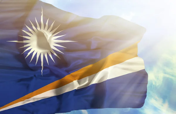 Marshall Islands waving flag against blue sky with sunrays — Stock Photo, Image