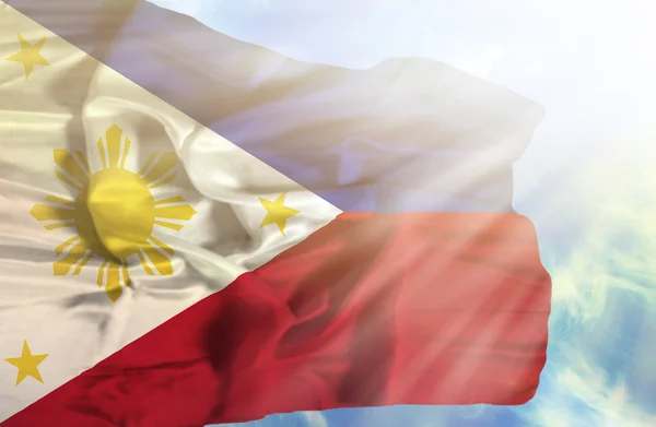 Phillipines ondeando bandera contra el cielo azul con rayos de sol —  Fotos de Stock