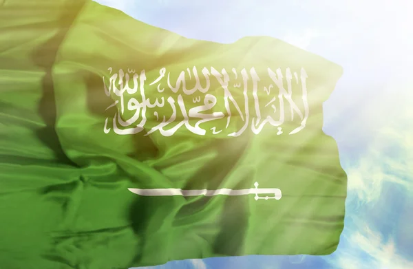 Saoedi-Arabië zwaaien vlag tegen blauwe hemel met zonnestralen — Stockfoto