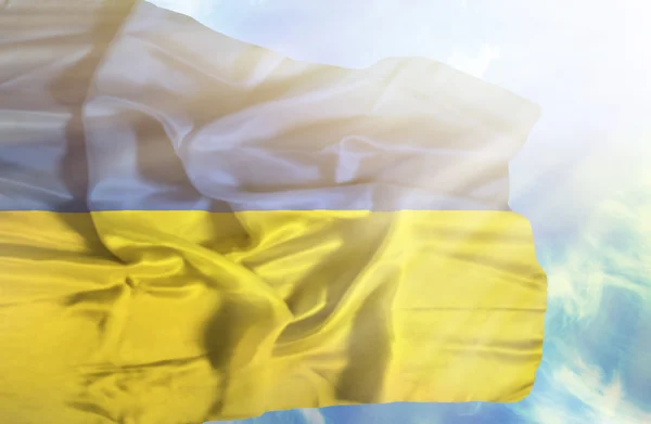 Ukraine agitant drapeau contre ciel bleu avec des rayons de soleil — Photo