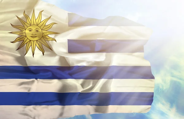 Uruguay viftande flagga mot blå himmel med solstrålar — Stockfoto