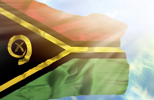 Vanuatu viftande flagga mot blå himmel med solstrålar — Stockfoto