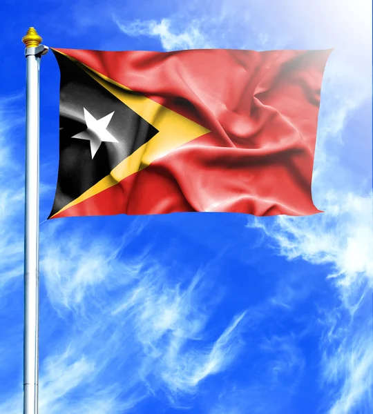 Ciel bleu et mât avec drapeau agitant pendu du Timor oriental — Photo