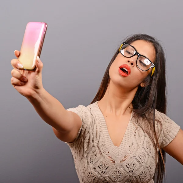 Retrato de una chica tomando selfie con teléfono celular contra bac gris —  Fotos de Stock