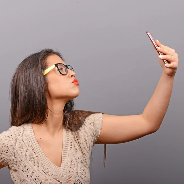 Porträt eines Mädchens beim Selfie mit dem Handy gegen grauen Bac — Stockfoto