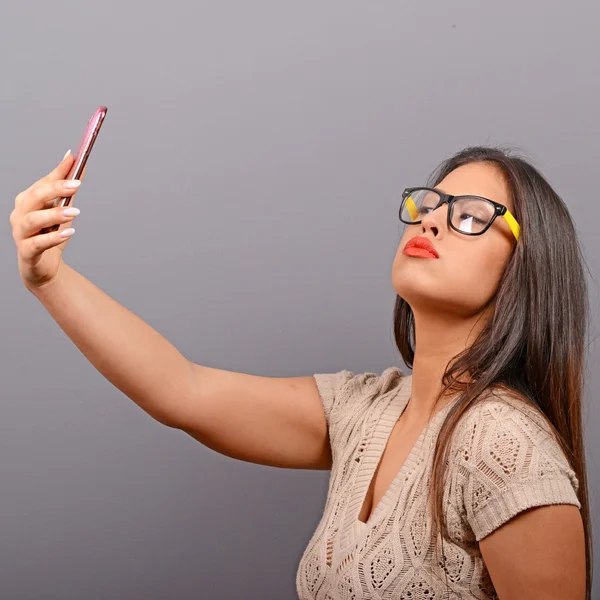 Ritratto di una ragazza che prende selfie con il cellulare contro il bac grigio — Foto Stock