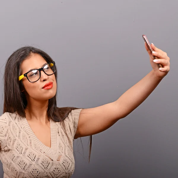 Retrato de una chica tomando selfie con teléfono celular contra bac gris —  Fotos de Stock