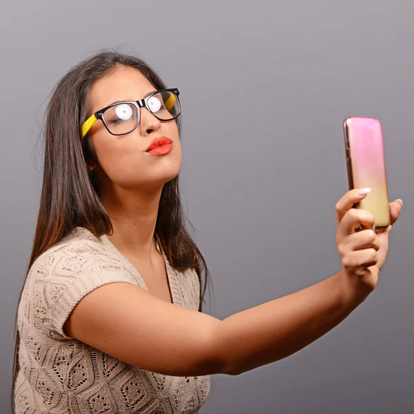 Retrato de una chica tomando selfie con teléfono celular contra bac gris — Foto de Stock