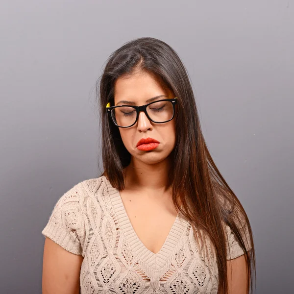 Retrato de uma mulher triste contra fundo cinza — Fotografia de Stock
