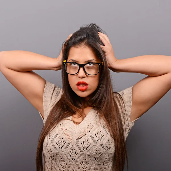 Portret kobiety zagniewany wyciągając włosy przed szary bac — Zdjęcie stockowe