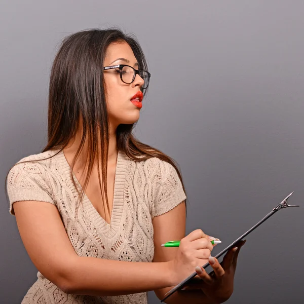 Porträt einer Geschäftsfrau mit Notizbuch vor grauem Hintergrund — Stockfoto
