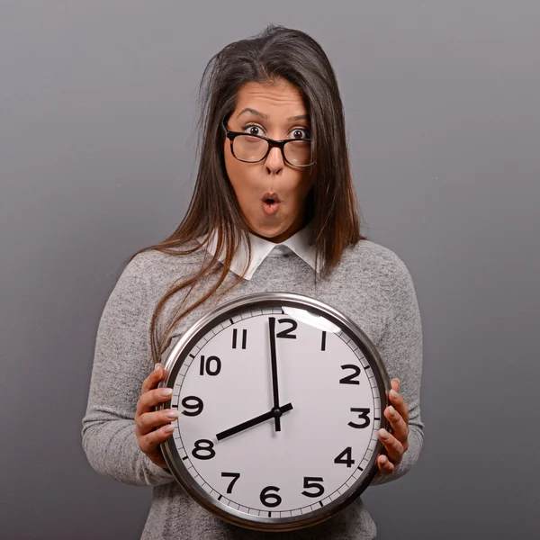 Retrato de mujer de negocios sosteniendo reloj contra fondo gris —  Fotos de Stock