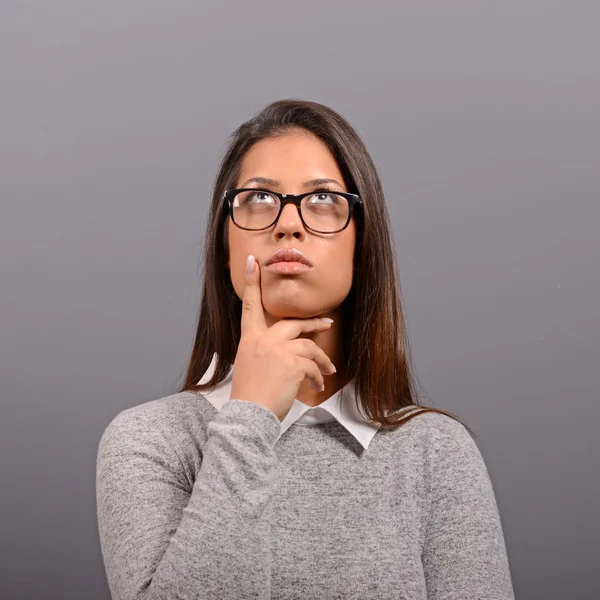 Portrait of thoughtful business woman against gray background — Stock Photo, Image