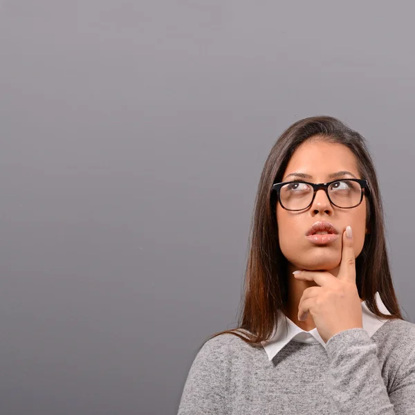 Portrait of thoughtful business woman against gray background — Stock Photo, Image