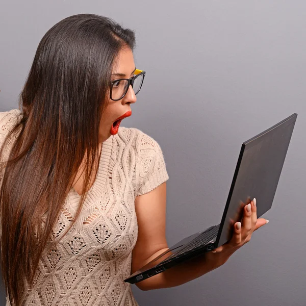 Portrait of woman in shock what she sees at her laptop against g — Stockfoto