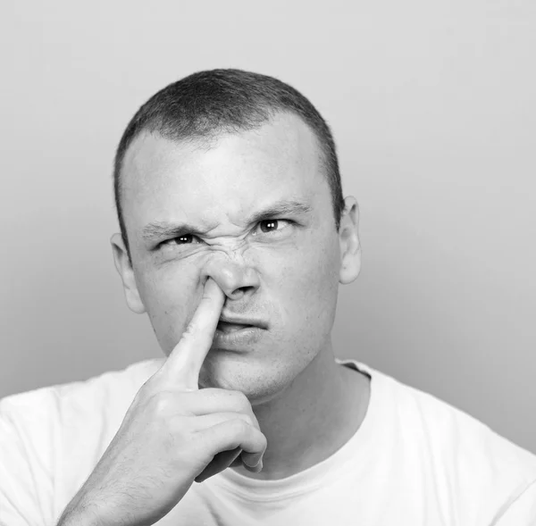 Portret van een jonge man met zijn vinger in zijn neus — Stockfoto