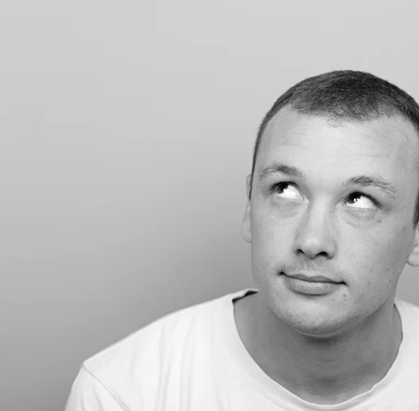 Portrait of man thinking and looking up against green background — Stock Photo, Image