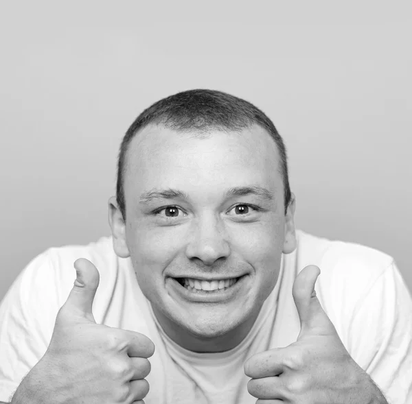 Портрет со смешным выражением лица, держащим большие пальцы против гри — стоковое фото