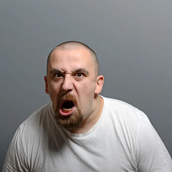 Portret zły człowiek krzyczący na szarym tle — Zdjęcie stockowe
