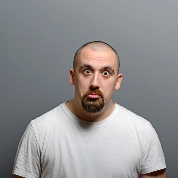 Retrato de um homem confuso contra fundo cinza — Fotografia de Stock