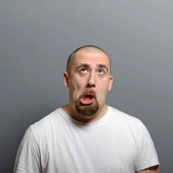 Retrato de un hombre haciendo cara graciosa sobre fondo gris —  Fotos de Stock