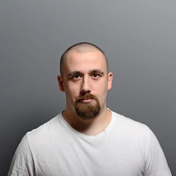 Retrato de un joven de pie sobre fondo gris — Foto de Stock