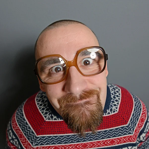 Portrait of a nerd with glasses and retro sweater against gray b — Stock Photo, Image