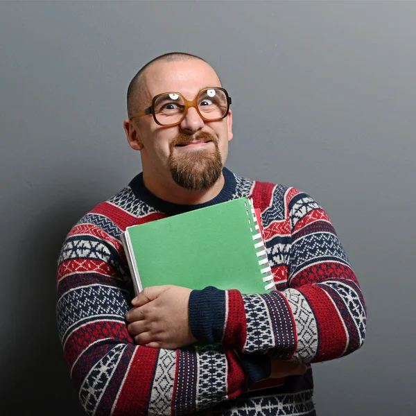 Retrato de un libro de celebración nerd con gafas retro contra gris —  Fotos de Stock