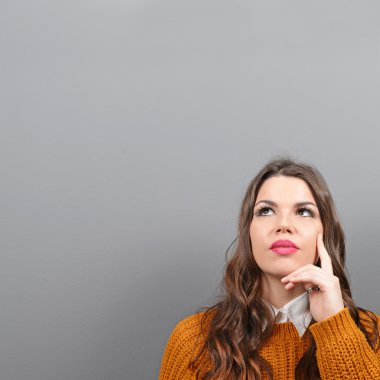 Güzel kadın gri arka plan boş alanı bakarak